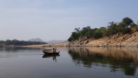 A-man-crossing-the-Cauvery-river-on-a-coracle-in-Hogenakkal,-Tamilnadu,-India