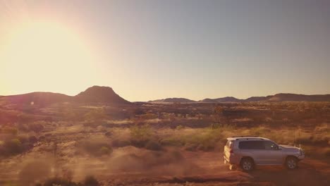 Aerial-Drone-low-tracking-4WD-Truck-down-gravel-road-in-Australian-Desert