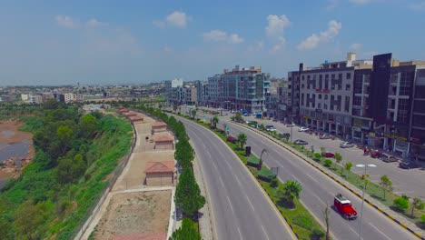 Model-road-with-buildings-and-river-drone-view,-cars-running,-Chitwan,-Nepal