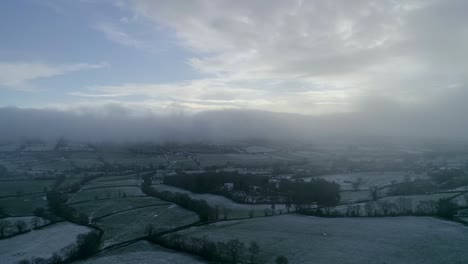 Aerial-tracking-sideways-through-a-misty-cold-and-snowy-field-scene