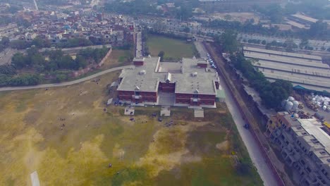 Aerial-flight-over-the-school-of-Bombay,-India,-Drone-camera-crossing-the-school,-children-playing-in-the-ground-of-the-school