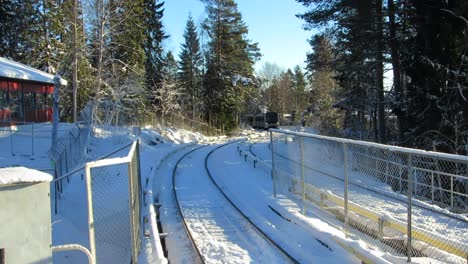 Train-coming-into-snowy-hillside-station