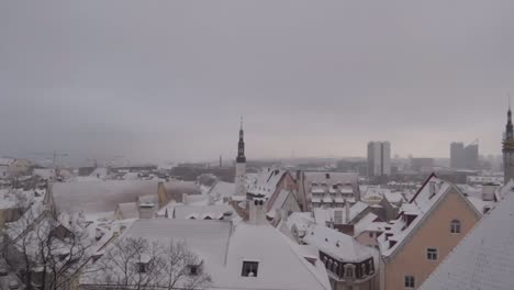Panning-top-view-of-Tallinn-old-town-during-moody-cloudy-day-in-winter-with-snow-covering-the-roofs