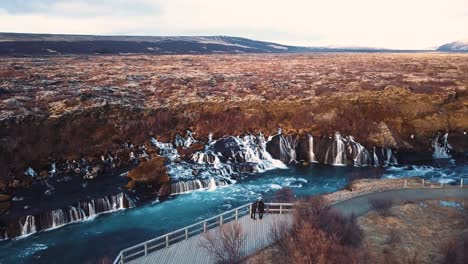 Drone-Con-Movimientos-Cinematográficos-Muestra-Una-Hermosa-Cascada-Islandesa,-Hraunfossar,-A-La-Luz-Del-Atardecer-Desde-Múltiples-ángulos