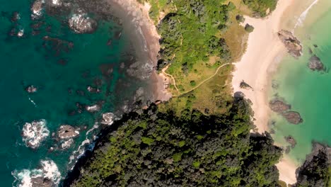 Aerial-drone-topdown-view-flying-over-a-narrow-paradise-peninsula-with-beaches-and-ocean