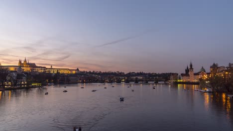 4K-timelapse-of-paddle-boats-on-Vltava-river-in-Prague-with-castle-and-Charles-Bridge-in-the-background,-zoom-in-view