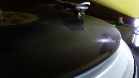 Closeup-of-a-turntable-spinning-a-record-LP,-with-the-LED-reflecting-the-spinning-grooves