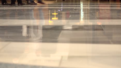 Reflections-and-feet-only-shot-of-people-walking-inside-busy-shopping-mall