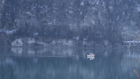 Small-fisher-boat-in-front-of-massiv-mountain