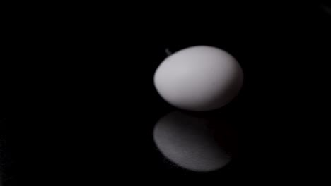Push-in-shot-to-a-white-egg-with-a-very-small-feather-on-it