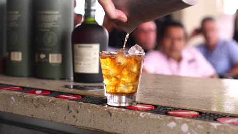Zeitlupenaufnahme-Eines-Alkoholischen-Cocktails,-Der-In-Einer-Bar-In-Der-Karibik-In-Ein-Glas-Mit-Eis-Gegossen-Wird