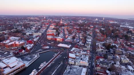 Purple-dawn-over-historic-downtown-Annapolis-and-state-capital-building,-aerial-wide-shot