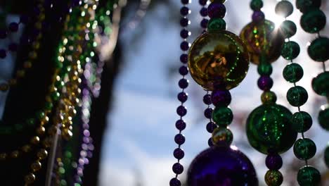 Sunny-outdoor-Mardi-Gras-beads-on-light-post-in-sunshine-blowing-in-wind