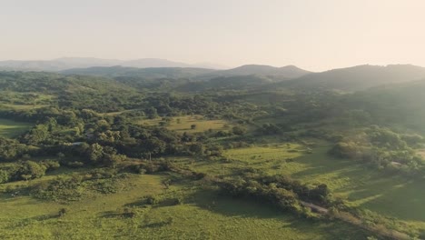 Drone-footage-panning-motion-to-the-right-revealing-far-mountains-during-a-sunrise