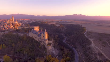 Luftaufnahme-Von-Segovia-Alcazar-Und-Stadt-Im-Herbst-Mit-Schönen-Baumfarben-Und-Sonnenuntergang