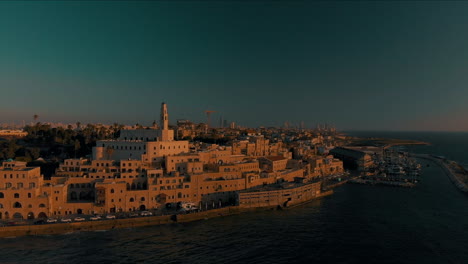 Tel-Aviv-Jaffa,-Flug-über-Den-Alten-Hafen-Von-Jaffa-Bei-Sonnenuntergang,-Skyline-Von-Tel-Aviv-Und-Das-Mittelmeer-Zur-Goldenen-Stunde,-Israel,-Sockelaufnahme