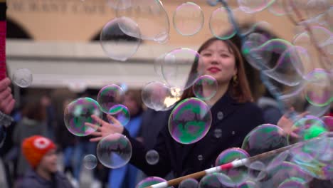 Beautiful-young-Korean-woman-surrounded-by-soap-bubbles-from-artist-in-Prague-City-Center
