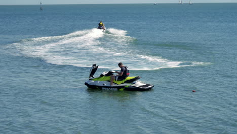 Footage-showing-two-men-on-jetbike-on-the-water,-one-who-is-not-moving-maybe-broken-down,-and-the-other-jetting-off-away-from-his-friend
