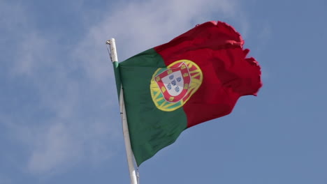 Portugal-Schwenkt-Die-Flagge-Mit-Leichten-Wolken,-Die-In-Der-Langsamen-Bewegung-Des-Hintergrunds-Monieren