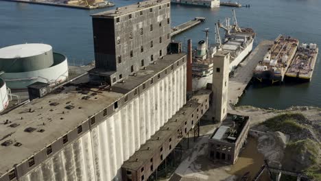 Aerial-flight-next-to-massive-abandoned-grain-terminal-and-industrial-ships-in-Brooklyn-New-York-City