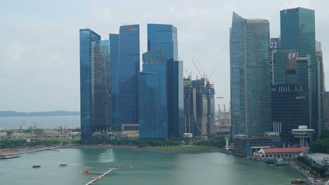Singapur---Alrededor-De-Lapso-De-Tiempo-Toma-Panorámica-De-Los-Famosos-Edificios-Altos-Financieros-De-La-Bahía-Del-Puerto-Deportivo-De-Singapur-En-El-Marco,-Cielo-Nublado-Durante-El-Día