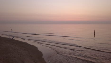 Aerial-shot-of-a-calm-Northsea-beach-during-sunset