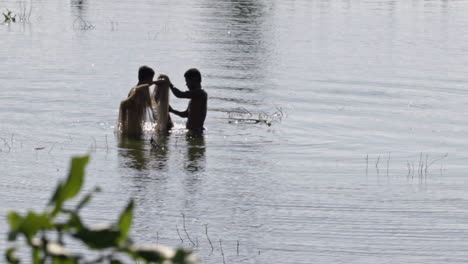 two-burmese-fisherman-standing-in-a-lake-in-myanmar
