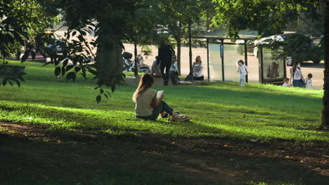 Girl-reading-book-in-Las-Heras-square-at-sunset,-Buenos-Aires