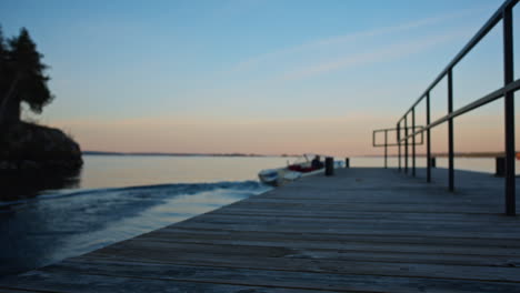 Motor-boat-leaving-the-dock-on-a-lake-during-sunset
