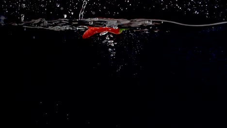 Vibrant-red-sweet-pepper-being-dropped-into-water-in-slow-motion