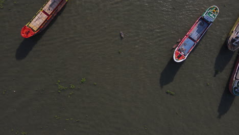 Antena:-Barcos-De-Carga-Más-Grandes-Que-Atracan-En-El-Puerto-Fluvial-De-Sadar-Ghat,-Dhaka,-Bangladesh