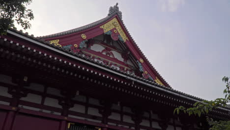 Asakusa-temple-in-Tokyo,-close-up-pan-over-roof-detail-on-popular-city-landmark
