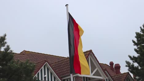 German-flag-in-the-wind-on-a-cold-rainy-day-with-gray-colors
