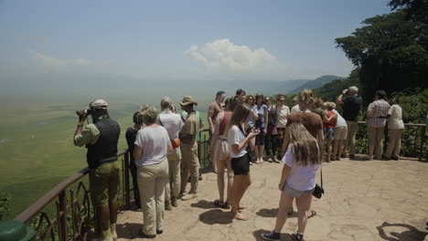 Tourists-watch-and-take-photos-at-the-observation-platform-of-Ngorongoro-crater-on-a-sunny-day,-Tanzania