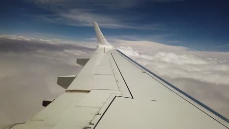 Verkehrsflugzeugflügel,-Der-Unter-Einem-Blauen-Himmel-Mit-Sonne-In-Eine-Dicke-Wolkenschicht-Eindringt