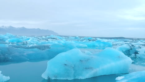 Forward-aerial-view-of-ice-blocks-in-a-lake,-in-a-quite-atmosphere