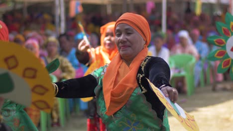 Nahaufnahme-Asiatischer-Muslimischer-Frauen,-Die-In-Heller-Kleidung-Tanzen-Und-Fächer-Halten,-Während-Sie-Den-Nationalen-Frauenmonat-Auf-Den-Philippinen-Feiern