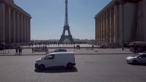 Weiter-Blick-Auf-Die-Esplanade-Des-Trocadero-Mit-Eiffelturm-Und-Vorbeifahrenden-Touristenbussen