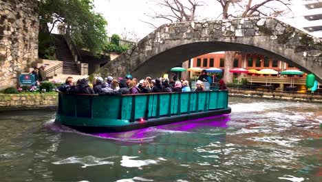 Bright-colorful-riverboats-traverse-the-downtown-area,-transportation-to-the-Riverwalk-areas