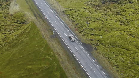 Aerial-view-of-car-traveling-along-a-road-into-nowhere-in-a-landscape-of-Iceland