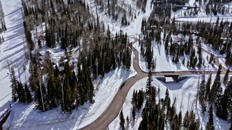 Park-City-Utah-Aerial-v43-drone-flyover-the-colony-white-pine-canyon-capturing-mountainside-mansions,-upward-inclining-the-steep-ski-slopes-on-a-sunny-day---Shot-with-Mavic-3-Cine---February-2022