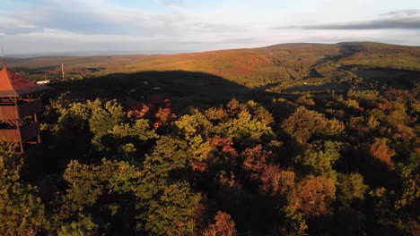 Backward-aerial-of-passing-by-Hárs-Hill-lookout-point-in-autumn-forest