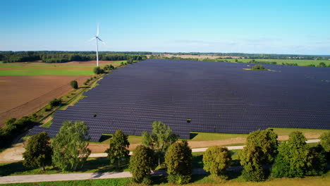 Solar-energy-production-farm-on-sunny-day-with-blue-sky-above,-aerial-orbit-left