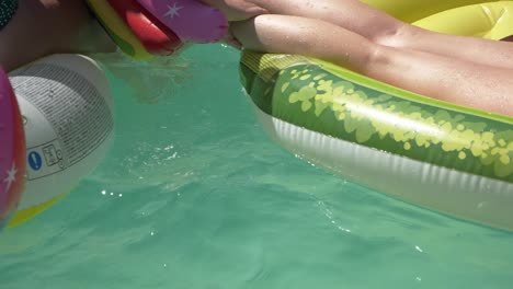 Close-Up-View-Of-Girls-Playing-On-Pool-With-Colorful-Floaties---slow-motion