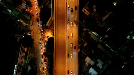Imágenes-Cinematográficas-De-Drones-Urbanos-De-4k-De-Una-Vista-Aérea-De-Automóviles-Conduciendo-En-La-Carretera-Con-El-Dron-Mirando-Hacia-Abajo-A-90-Grados,-En-El-Medio-Del-Centro-De-Bangkok,-Tailandia-En-La-Noche