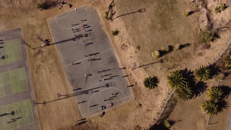 Top-view-down-drone-flight-over-people-playing-handball-on-a-field