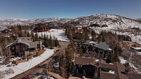 Park-City-Utah-Aerial-v14-snowy-winter-mountainscape-view,-drone-low-level-fly-around-hilltop-luxurious-mansions-capturing-expensive-home-under-construction---Shot-with-Mavic-3-Cine---February-2022