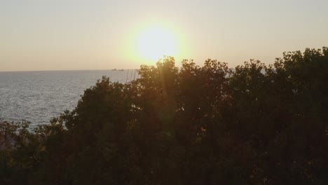 Antenne---Enthüllen-Sie-Den-Küstensteg-Von-Thessaloniki-Und-Das-Wahrzeichen-Der-Sonnenschirme-Mit-Menschen,-Die-Bei-Sonnenuntergang-Spazieren-Gehen