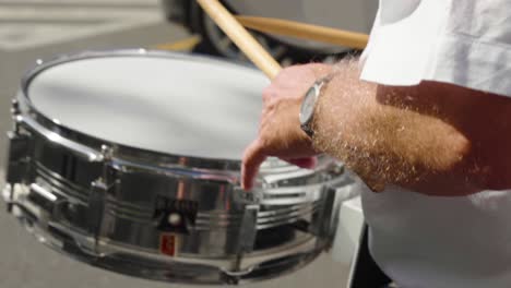 Orchestra-man-playing-a-mobile-bass-drum-with-drumsticks-during-ceremony---Close-up,-slow-motion
