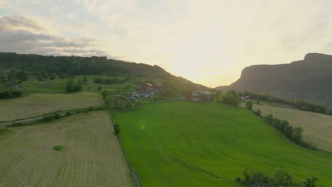 Aerial-View-Of-Sunset-In-Rural-Field-Setting-Behind-The-Mountains